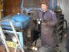 Tässä korjaamon omistaja Jari puuhastelee traktorin moottorin kimpussa.